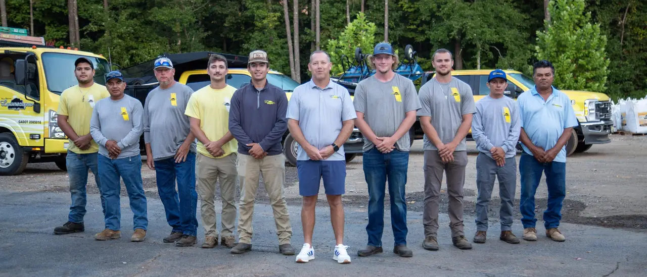The All South Lawnscapes crew standing together in front of company trucks