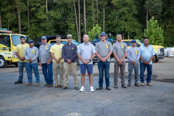 The All South Lawnscapes crew standing together in front of company trucks