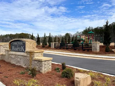Brick entrance monument with plantings and a boulder at Oakchase at Hampton