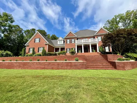 Brick terraced retaining walls and steps below a large brick home