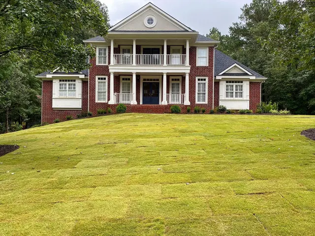 Brick home with new sod and planting beds