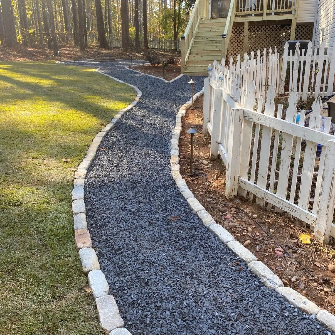 Gravel garden path edged with natural stone and lit by path lights