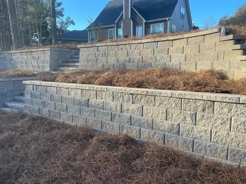 Segmental block retaining wall with a pine-straw planting bed